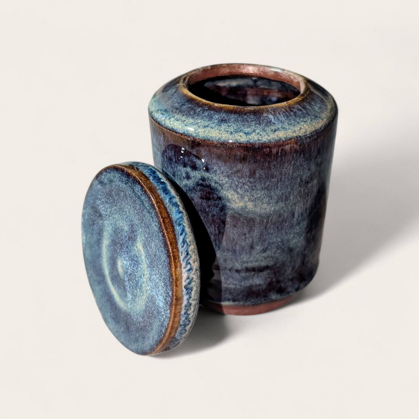 Stoneware jar with a lid on a light gray background